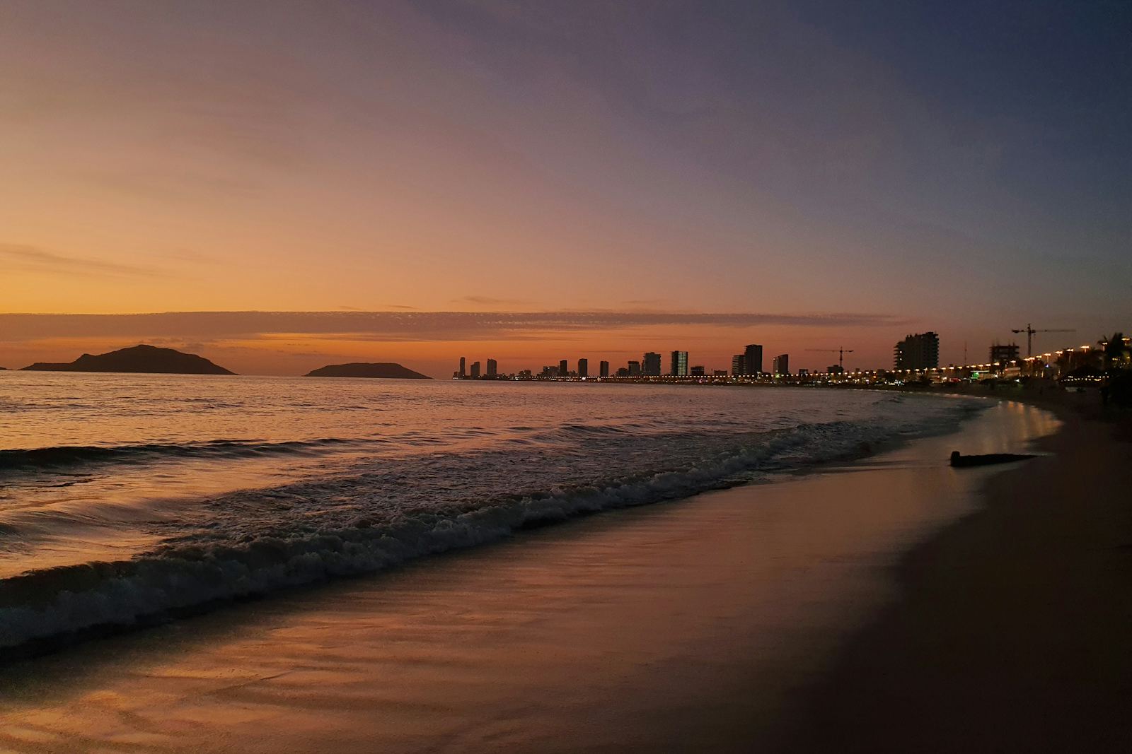 MazatlΓ‘n beach at sunset with the city skyline and islands, Mexico