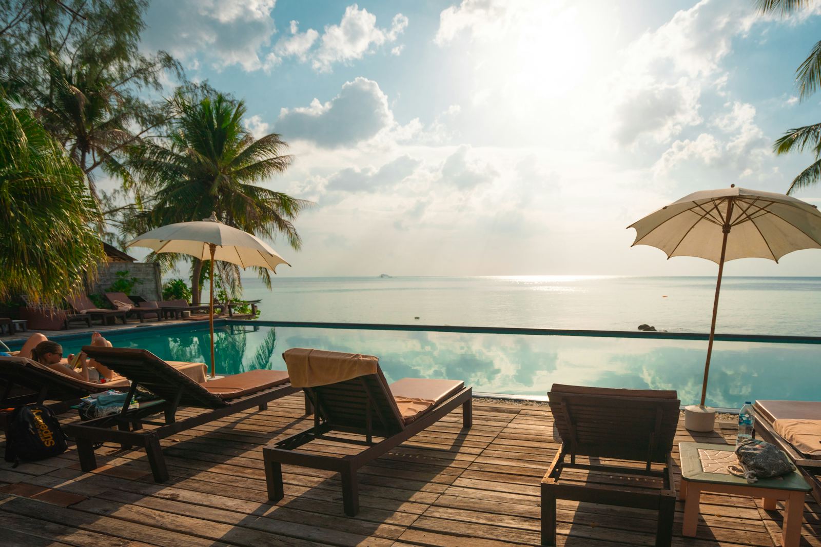Beachfront infinity pool at a tropical resort at sunset